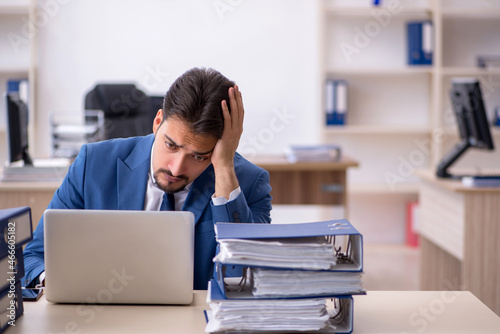 Young businessman employee unhappy with excessive work in the of