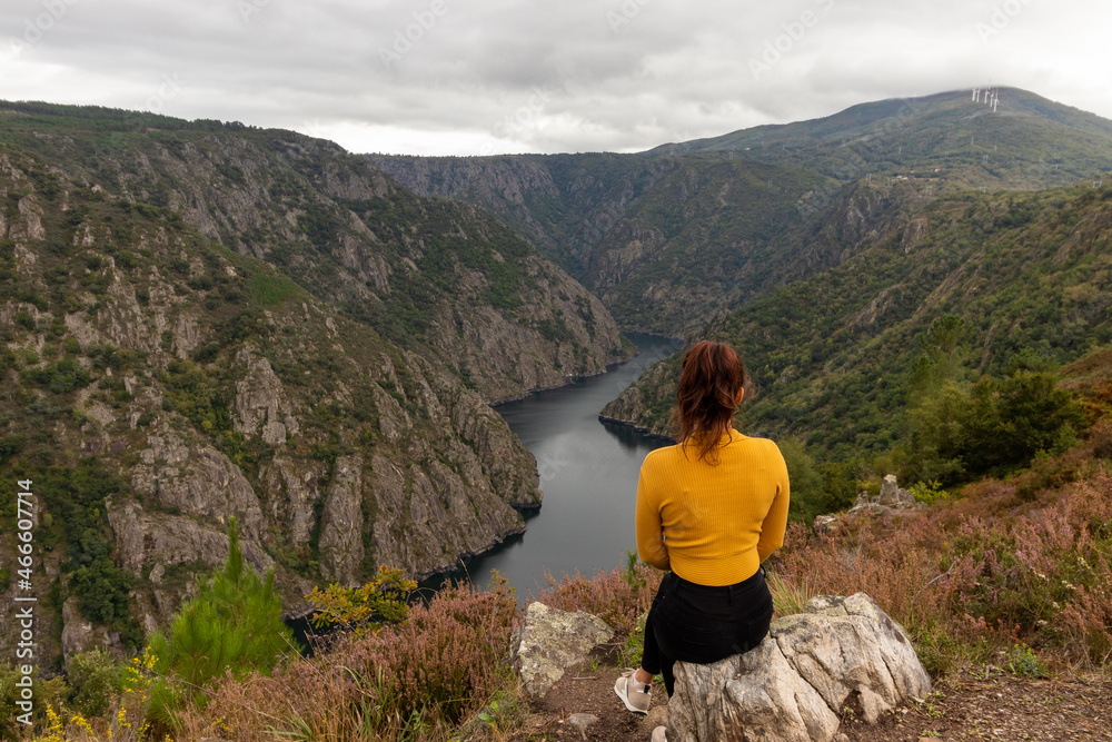 Impressive viewpoint of the Sil Canyon(Canon do Sil) in the Ribeira Sacra, with a girl in a yellow sweater in the foreground, in Galicia Impressive viewpoint of the Sil Canyon(Canon do Sil) in the Ribeira Sacra, with a girl in a yellow sweater in the foreground, in Galicia