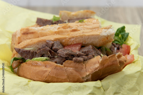 Loaded Tikka steak sub sandwich bursting with fillings in a freshly baked bun photo