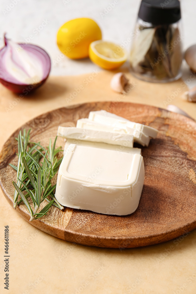 Plate with cut feta cheese and rosemary on light background