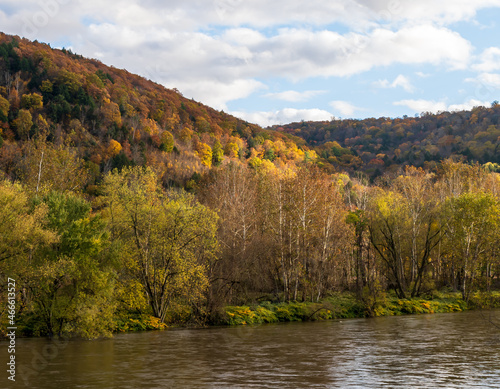 Fototapeta Naklejka Na Ścianę i Meble -  Colorful fall trees under sunny skies next to the Allegheny River in Althom, Pennsylvania, USA on an autumn day