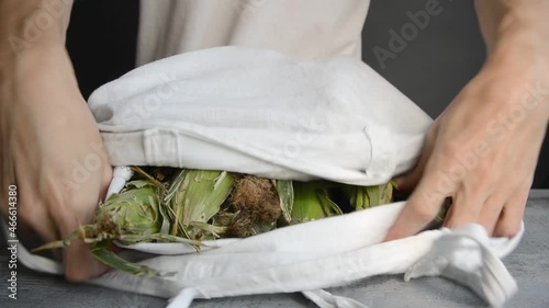 caucasian man came , brought in white eco fabric cotton tote bag, put fresh ripe ear corn on stone table top, and gone, lifestyle close-up horizontal stock video footage in real time