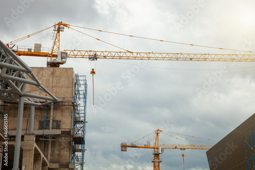 Construction site with yellow lifting crane and blue sky background.