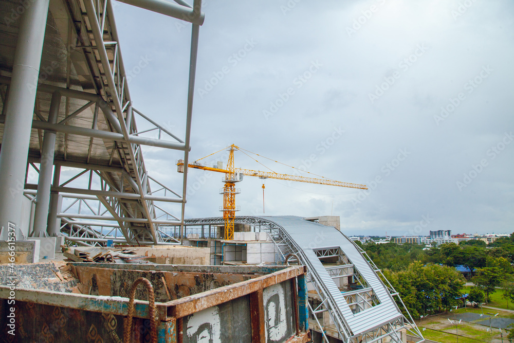 Construction site with yellow lifting crane and blue sky background. Construction site with yellow lifting crane and blue sky background.