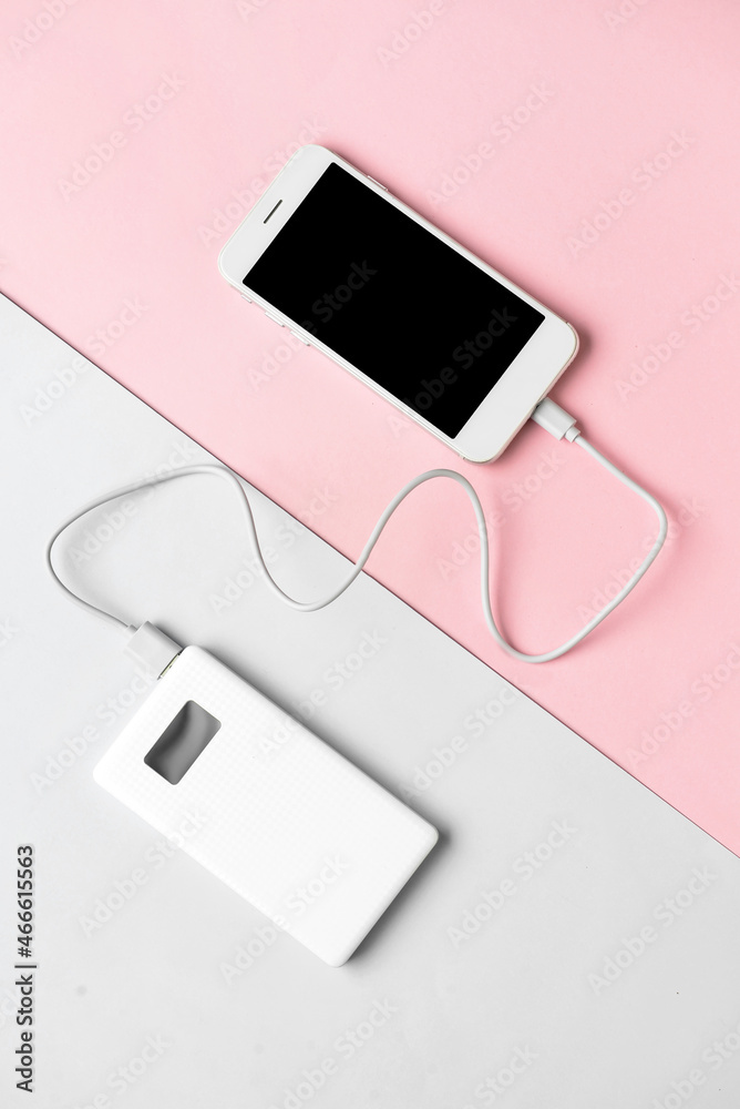 New power bank and mobile phone on color background New power bank and mobile phone on color background