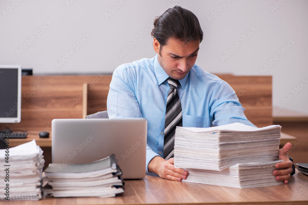 Young male employee unhappy with excessive work Young male employee unhappy with excessive work