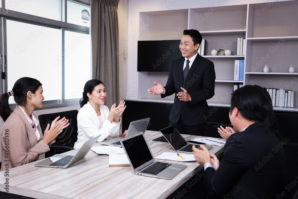 Group of business people applauding sitting at the negotiating table in meeting room. Selective focus Group of business people applauding sitting at the negotiating table in meeting room. Selective focus