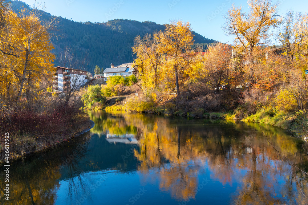 Waterfront hotels and inns along the Wenatchee River near Blackbird Island during Autumn in the Bavarian themed town of Leavenworth, Washington, USA.