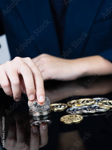 Woman holding some pieces of golden Bitcoin token