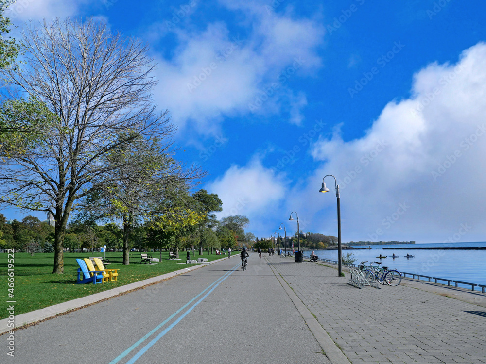 Runners and cyclists enjoy a warm day on the recreational trail beside Lake Ontario near downtown Toronto.