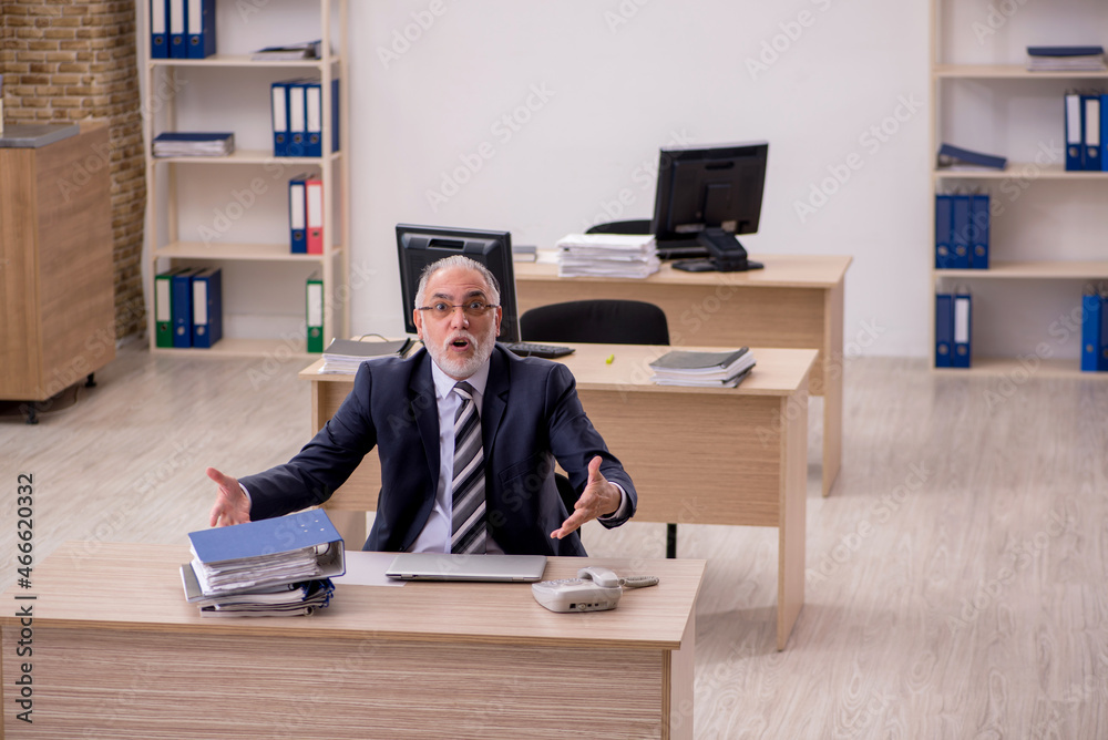 Aged businessman employee sitting in the office Aged businessman employee sitting in the office