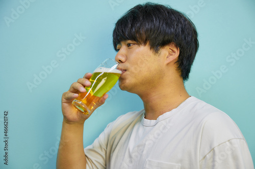 美味しそうにビールを飲む若いアジア人男性 