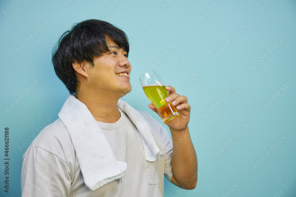 美味しそうにビールを飲む若いアジア人男性	
