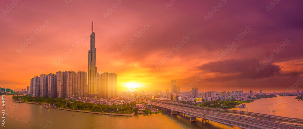 Aerial sunset view at Landmark 81 is a super tall skyscraper in center Ho Chi Minh City, Vietnam and Saigon bridge with development buildings, energy power infrastructure.