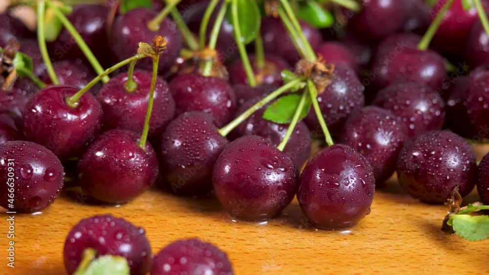 Dark red cherries with water drops. Organic fruit on wooden surface. Sweet ripe juicy food background Dark red cherries with water drops. Organic fruit on wooden surface. Sweet ripe juicy food background