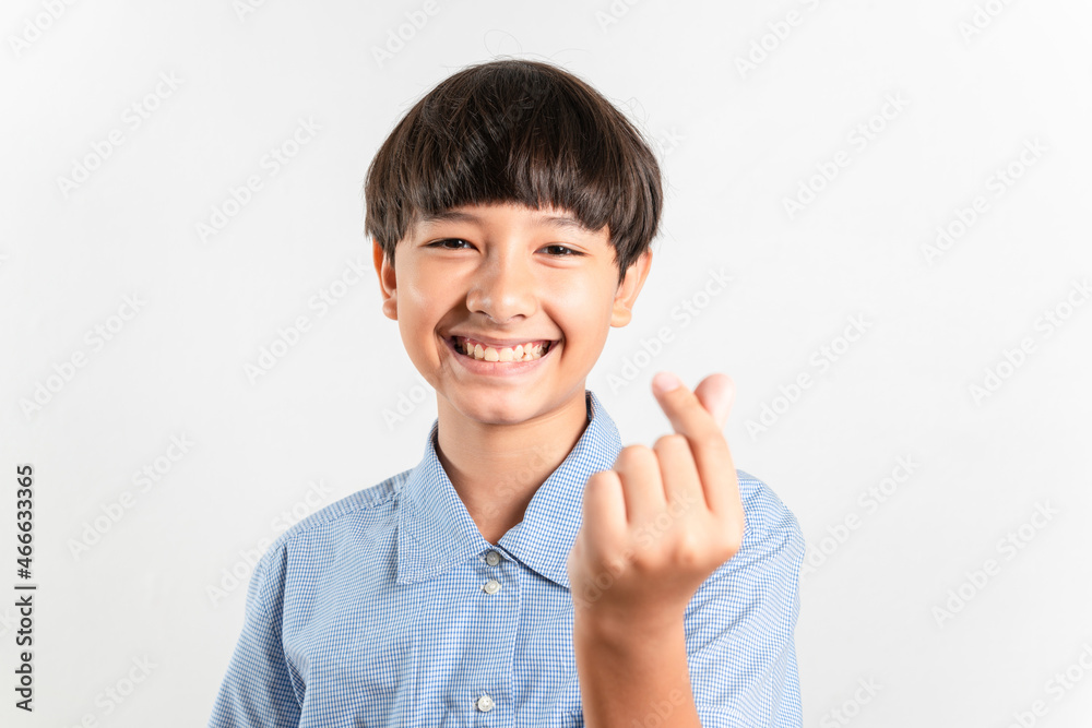 Portrait of adorable young lovely mixed race boy showing heart shape with his fingers looking at camera wearing a casual school look, Romantic concept. Isolated on white background for copy and space Portrait of adorable young lovely mixed race boy showing heart shape with his fingers looking at camera wearing a casual school look, Romantic concept. Isolated on white background for copy and space