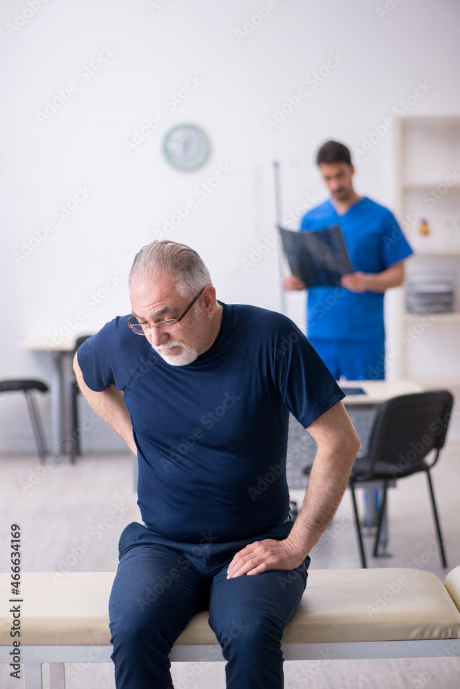 Old man visiting young male doctor radiologist Old man visiting young male doctor radiologist