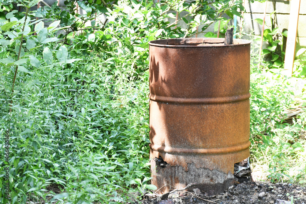 Old rusty brown oil tanks in the garden, industrial waste is useless. Old rusty brown oil tanks in the garden, industrial waste is useless.