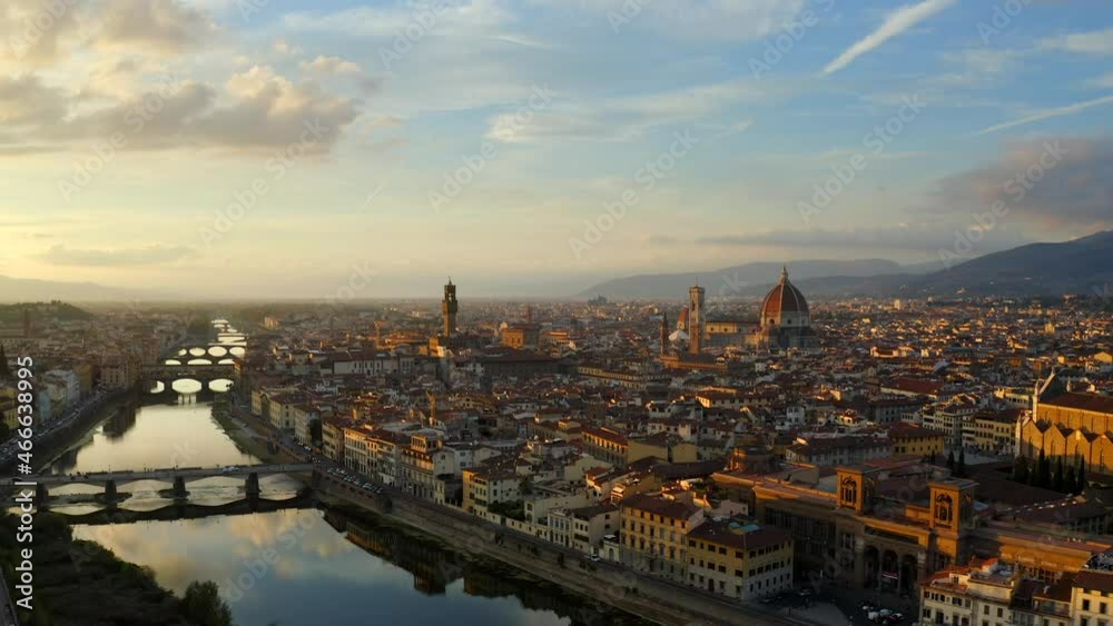 Florence, Tuscany, Italy, October 2021. Drone gradually ascends while pulling back from the Arno river facing west towards the Cathedral of Santa Maria del Fiore and Palazzo Vecchio at sunset. Florence, Tuscany, Italy, October 2021. Drone gradually ascends while pulling back from the Arno river facing west towards the Cathedral of Santa Maria del Fiore and Palazzo Vecchio at sunset.