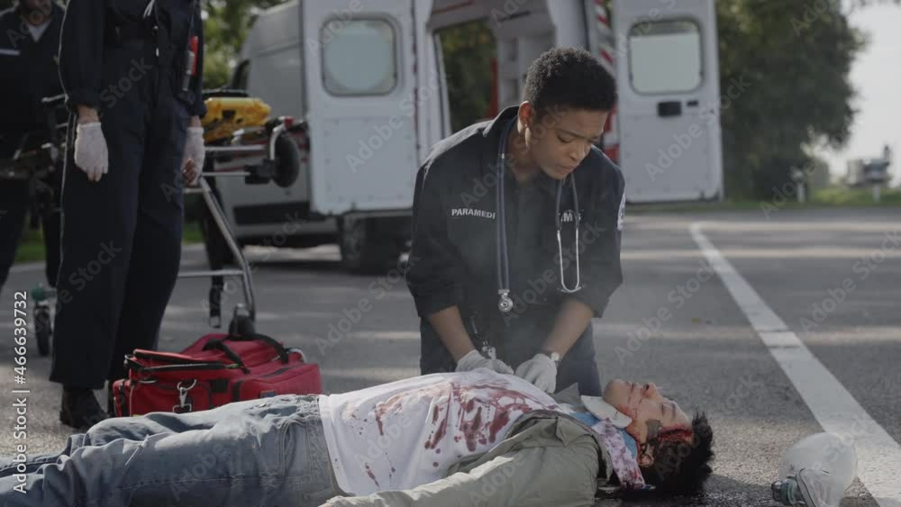 Team of EMS Paramedics trying to help car accident victim Team of EMS Paramedics trying to help car accident victim