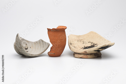 Archeologia: frammenti di vasetti e ciotole di epoca romana di vari materiali e colori, isolate su fondo bianco  photo