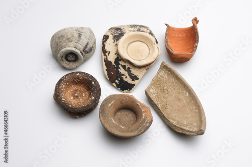 Archeologia: frammenti di vasetti e ciotole di epoca romana di vari materiali e colori, isolate su fondo bianco  photo