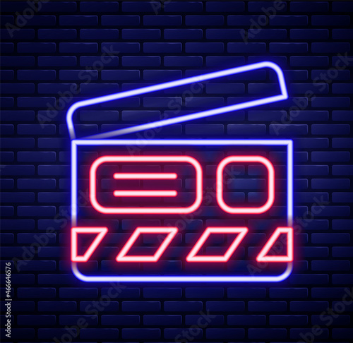Glowing neon line Movie clapper icon isolated on brick wall background. Film clapper board. Clapperboard sign. Cinema production or media industry. Colorful outline concept. Vector