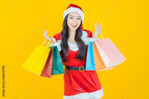 Portrait young asian woman wear christmas costume with action on yellow background