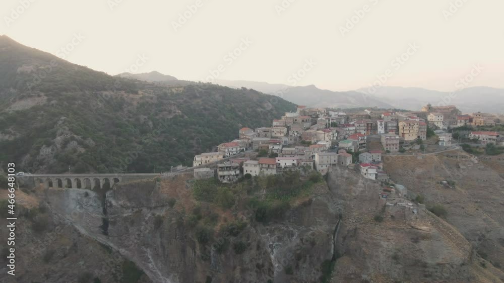 Arieal shot of a mountain village in Calabria (Italy) during sunset. In the background you can see mountains and valleys a bridge on the left side. Arieal shot of a mountain village in Calabria (Italy) during sunset. In the background you can see mountains and valleys a bridge on the left side.