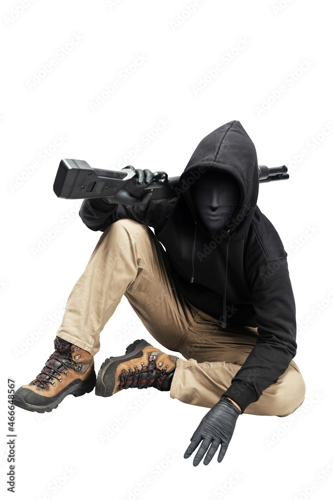 Criminal man in a hidden mask sitting and holding the shotgun
