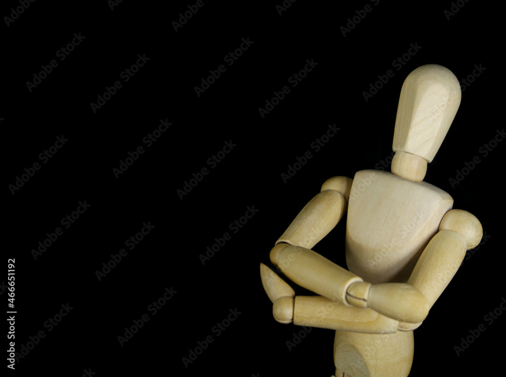 Wooden figurine isolated on black background, copy space for text Wooden figurine isolated on black background, copy space for text