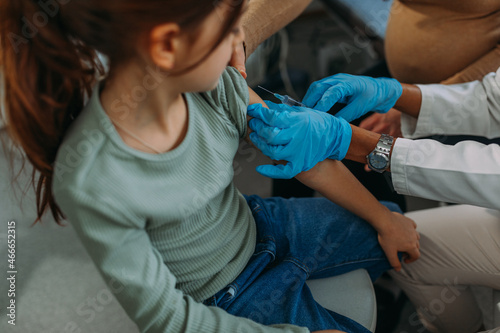 Girl patient in pediatrician's office getting vaccination