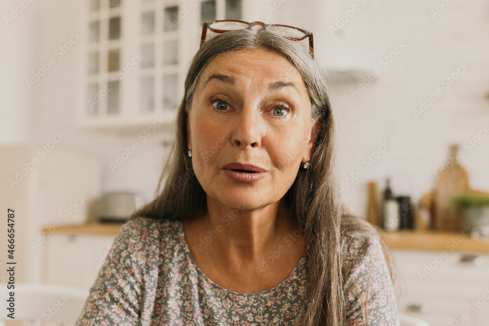 Elderly woman blogger astrologist, posing in front of camera, giving daily astrological forecast for her followers of social network page, having pretty, natty face, captured talking Elderly woman blogger astrologist, posing in front of camera, giving daily astrological forecast for her followers of social network page, having pretty, natty face, captured talking