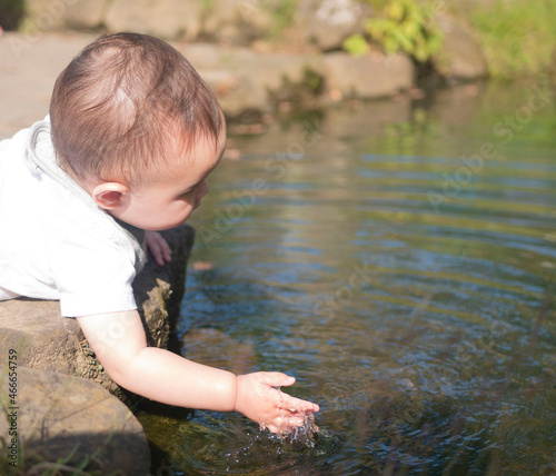 池の水で遊ぶハーフの赤ちゃん