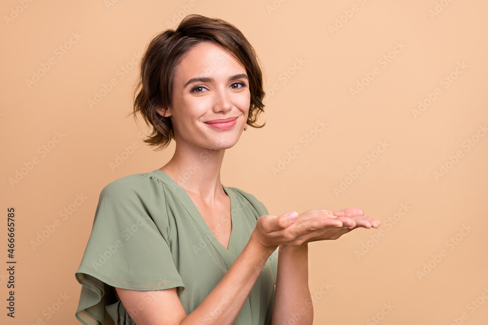 Obraz premium Photo of positive reliable lady hands presenting empty space wear green dress isolated beige color background