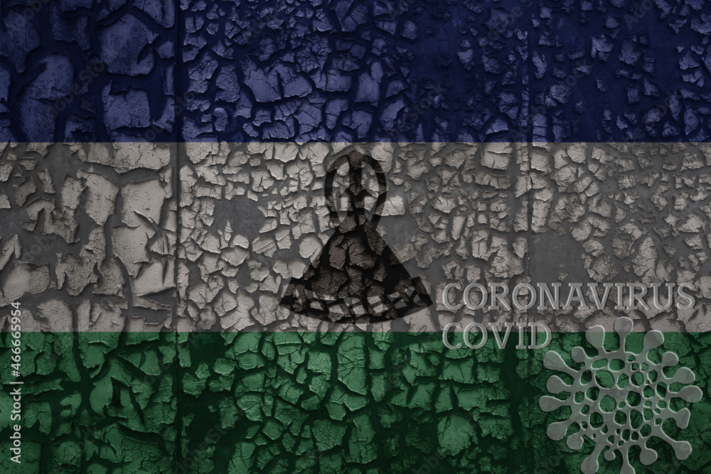 flag of lesotho on a old metal rusty cracked wall with text coronavirus, covid, and virus picture.