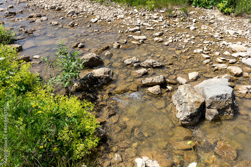 Mountain range, sources, hiking trail along the bank of a mountain river, natural stone, background, panoramic views of the mountainous terrain.