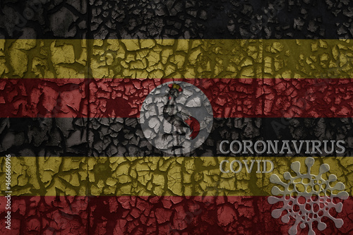 flag of uganda on a old metal rusty cracked wall with text coronavirus, covid, and virus picture.
