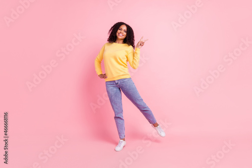 Photo of funny charming dark skin woman wear yellow sweater showing v-sign isolated pink color background