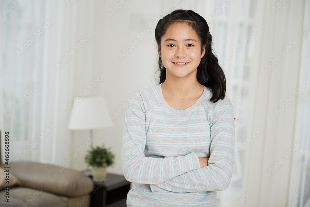 Portrait of pretty smiling teenage girl standing with arms crossed and smiling at camera Portrait of pretty smiling teenage girl standing with arms crossed and smiling at camera