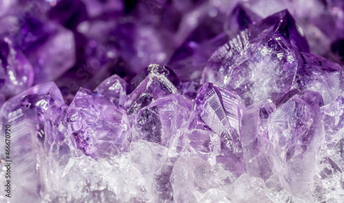 Amethyst purple crystals. Gems. Mineral crystals in the natural environment. Texture of precious and semiprecious stones. Seamless background with copy space colored shiny surface of precious stones. photo