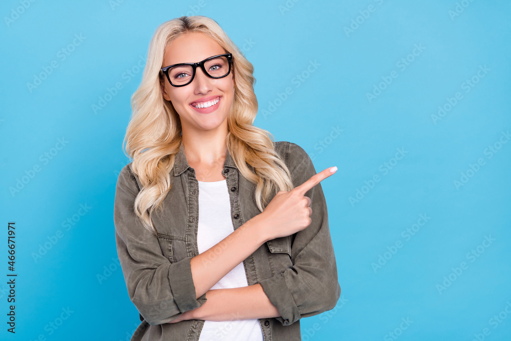 Photo portrait woman wearing glasses pointing finger blank space laughing isolated pastel blue color background Photo portrait woman wearing glasses pointing finger blank space laughing isolated pastel blue color background