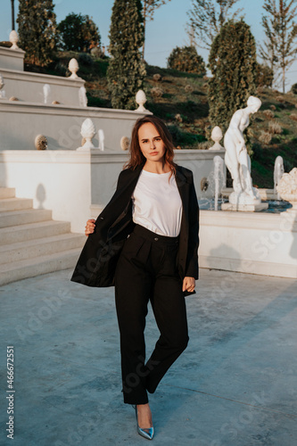 young woman in a trouser suit on the background of a park