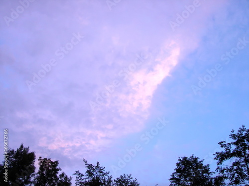 Panorama of the evening cloudy sky over the Transcarpathian forests illuminated by the rainbow colors of the sunset.  © Hennadii