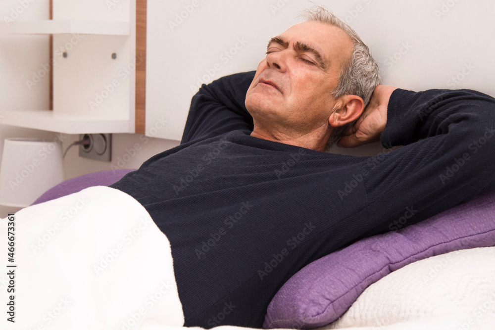 Fototapeta premium man relaxed and lying in bed at home
