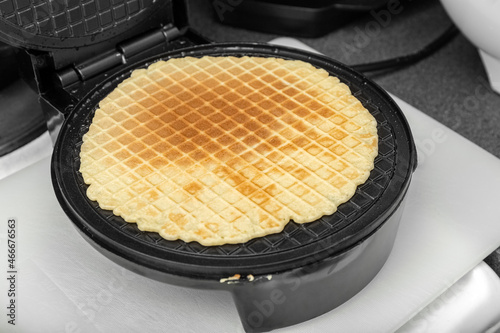 The waffles are baked in an electric waffle iron. Homemade baking. Close up. Photo