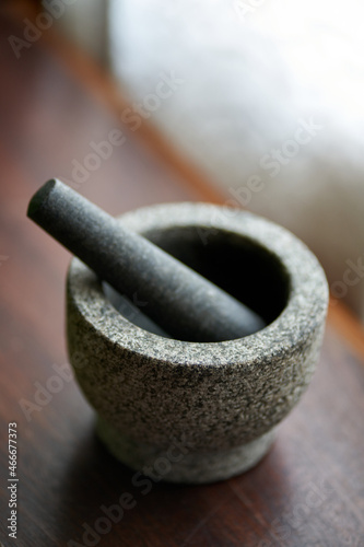 Photo Vertical shot of a stone mortar with pestle on a wooden surface