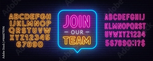 Join Our Team neon sign on a brick background.