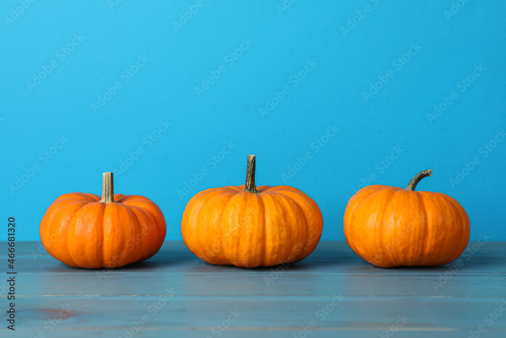 Fresh ripe pumpkins on turquoise wooden table, space for text Fresh ripe pumpkins on turquoise wooden table, space for text
