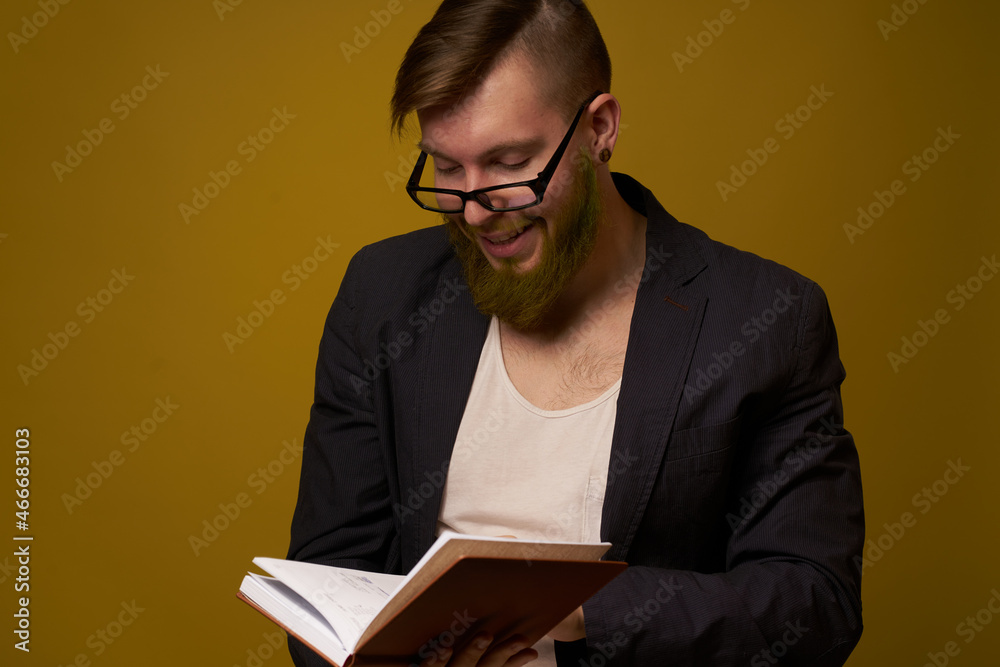 bearded man in a black jacket with a book in his hands education bearded man in a black jacket with a book in his hands education